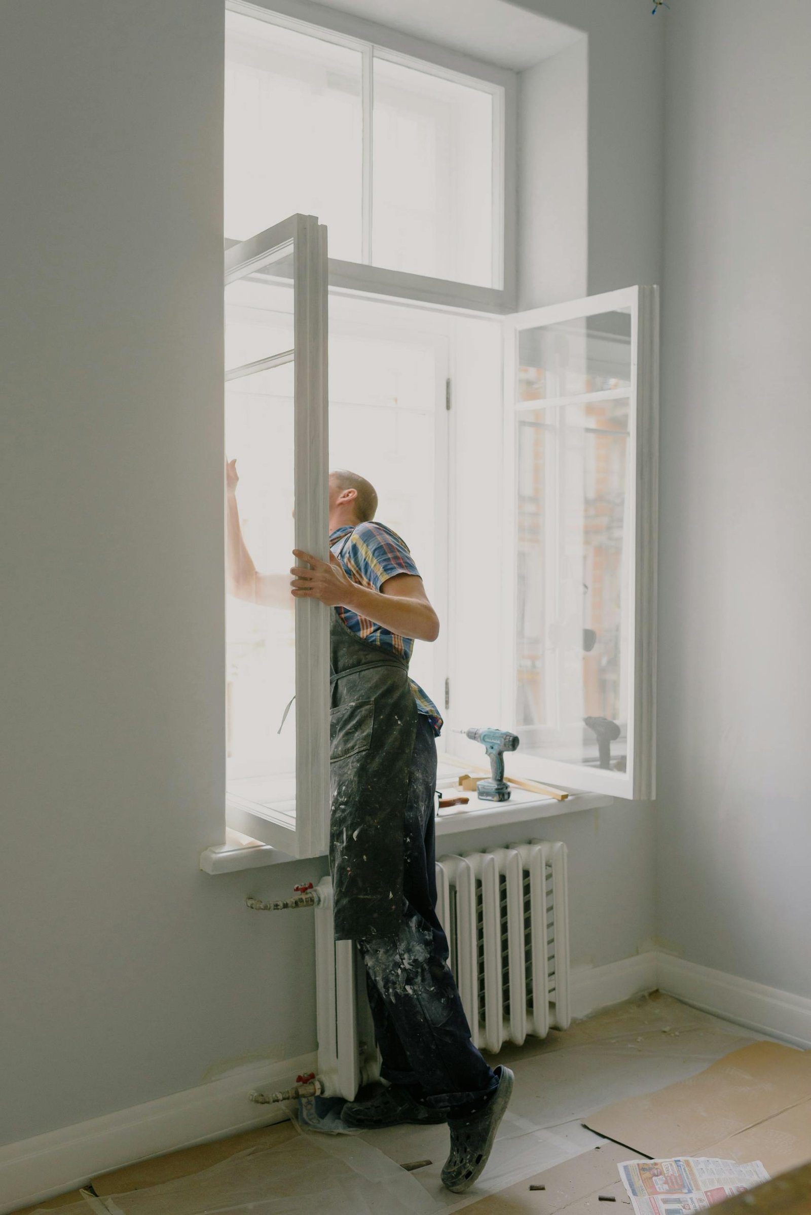 Professional installing a window in a bright modern apartment interior.